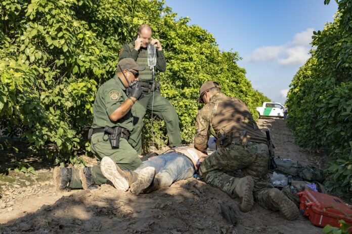 U.S. Border Patrol agents give medical aid to a Mexican national