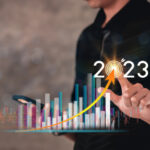 Businessman touch the glow light Data digital marketing graph and chart with arrow up.positive indicators in 2023, businessman calculates financial data for long-term investments.