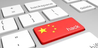 Closeup of keys on a computer keyboard, with one bearing the Chinese flag colors and a label for hacking.