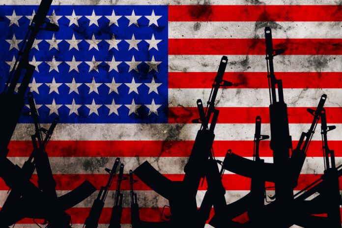 Several automatic rifles raised up on the background of the American flag. High quality photo