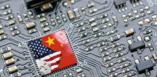 Flag of USA and China on a processor, CPU or GPU microchip on a motherboard. US companies have become the latest collateral damage in US - China tech war. US limits, restricts AI chips sales to China.