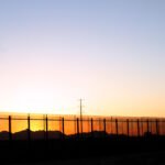 The border fence at sunset on the United States side of the lower valley in El Paso, Texas facing towards the Juarez,Mexico Mountains.